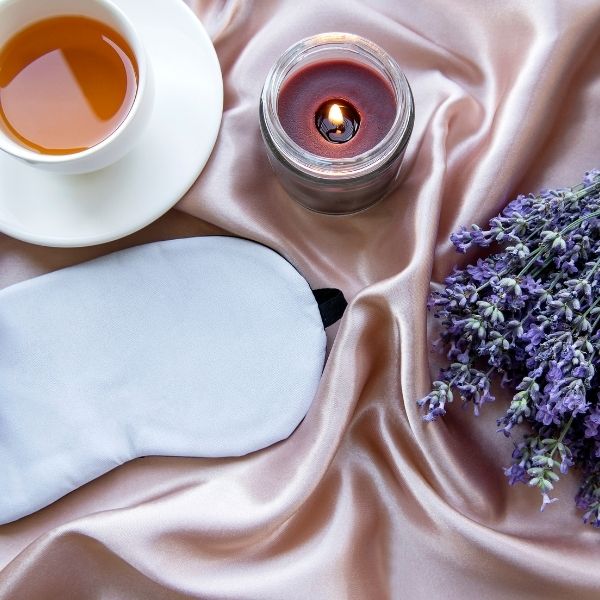 tea, sleep mask, candle, and lavender for natural sleep aids