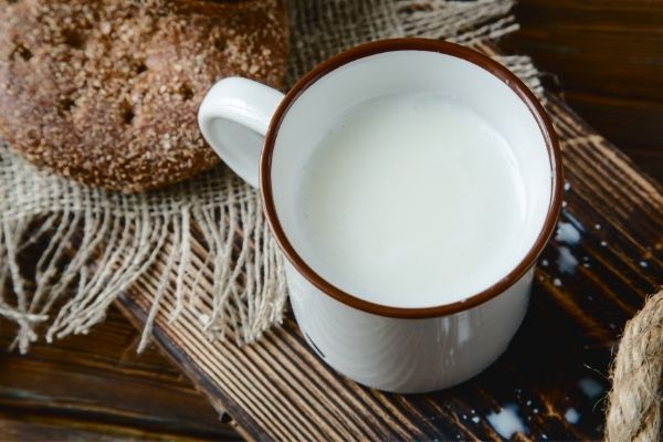 white cup with brown trim full of warm milk for natural sleep aid