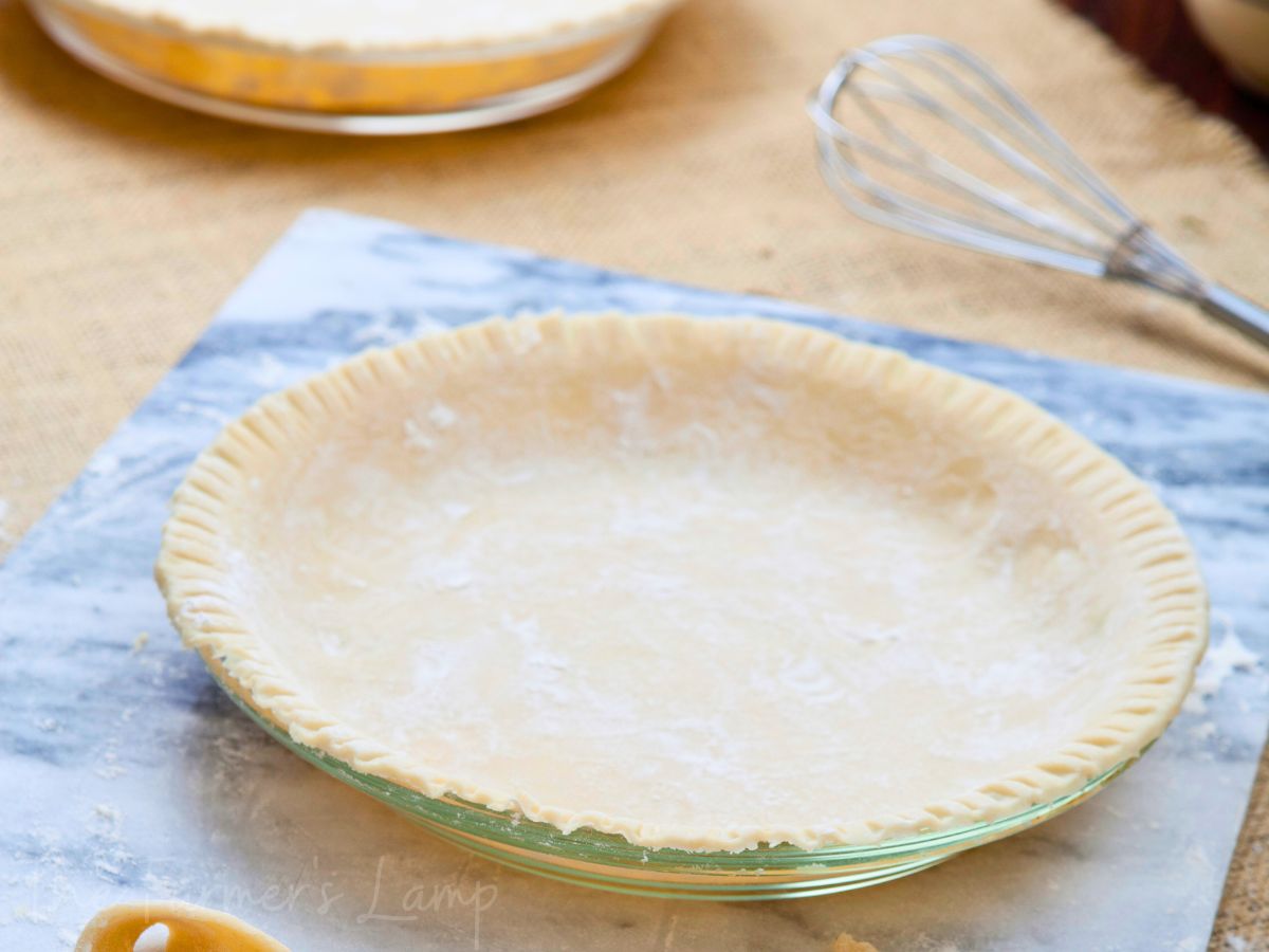 einkorn flour pie crust in a clear glass pie plate ready to bake