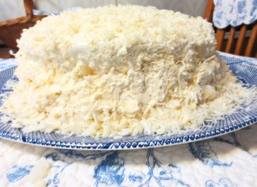 old fashioned layered coconut cake on a blue willow plate