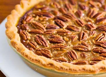 old fashioned southern pecan pie in a clear glass pie plate