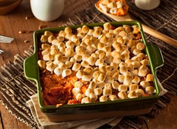 sweet potato casserole with marshmallows on top in a green casserole dish