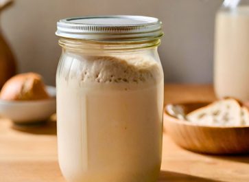 sourdough starter in a clear glass jar sitting on my counter
