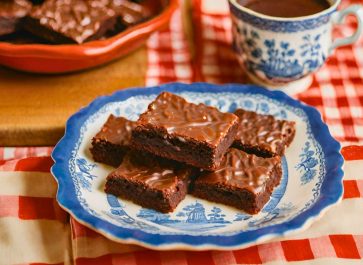 fudgy chewy homemade brownies on a blue willow plate sitting on a red gingham tablecloth