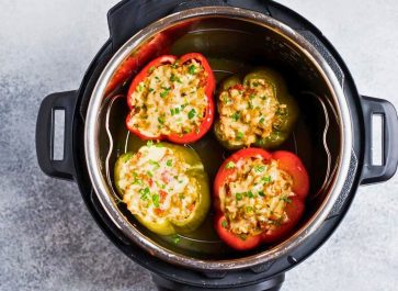 four stuffed bell peppers in an instant pot after cooking two red peppers and two green peppers